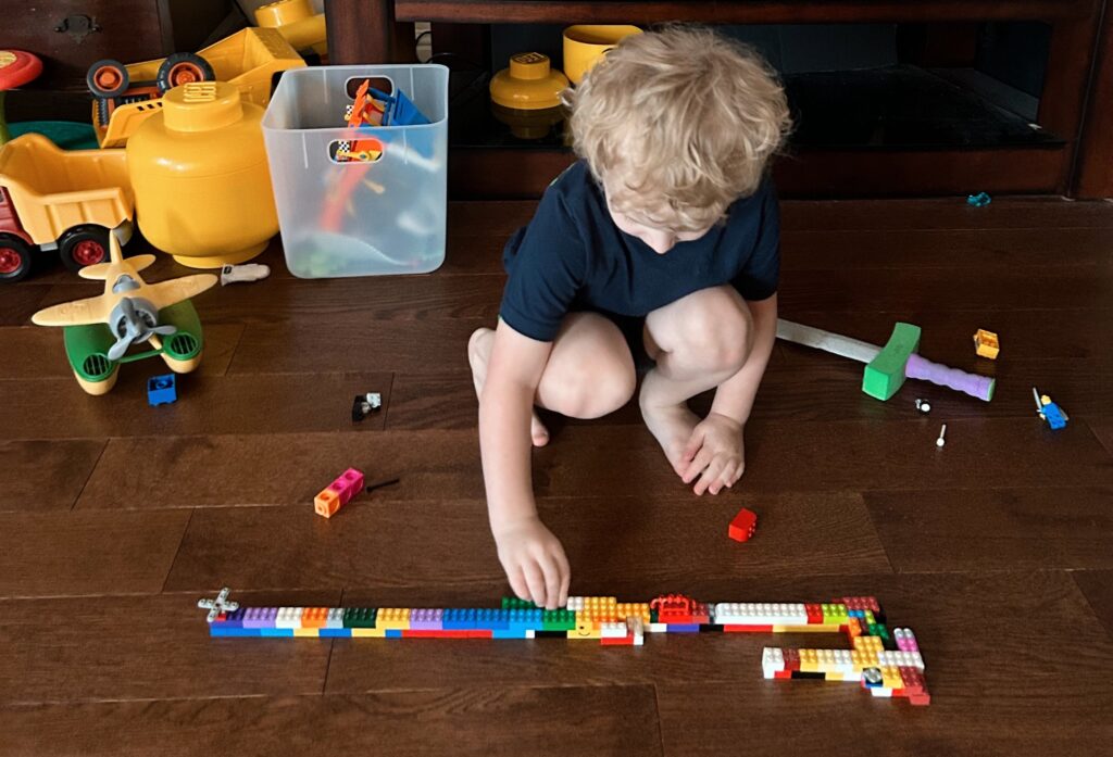 Child building a line out of LEGO