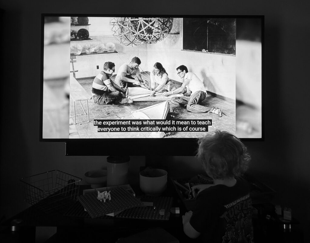 Black and white photograph of a child building LEGO with a Black Mountain College documentary of students building beneath a geodesic dome behind.