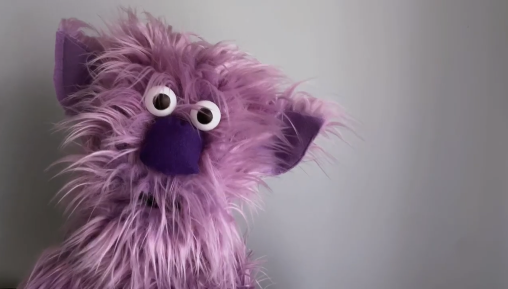 Purple muppet style puppet with fluffy fur and ears