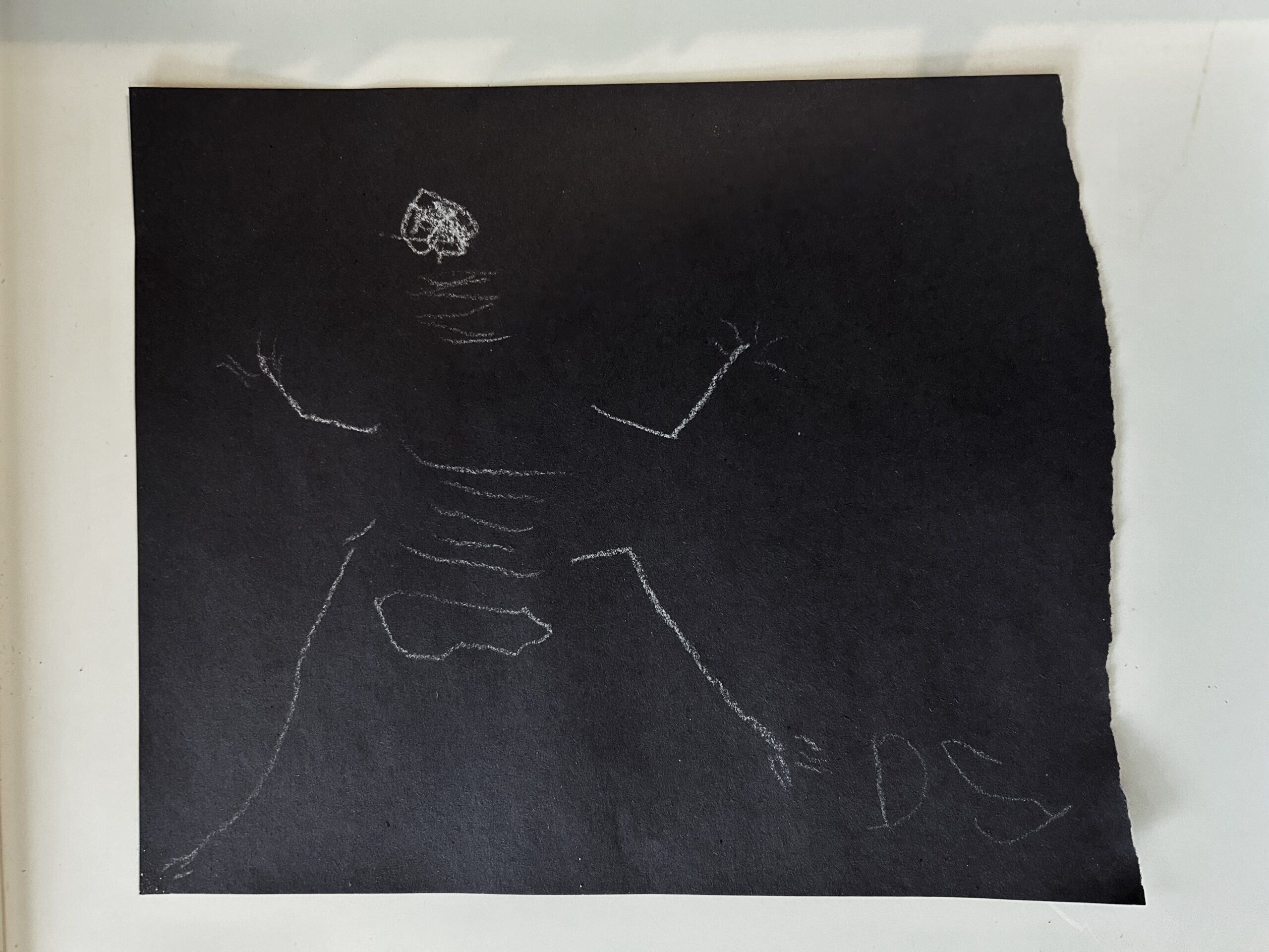 Child drawn skeleton white on black paper