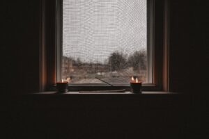 Candle on a windowsill on a rainy and gloomy day