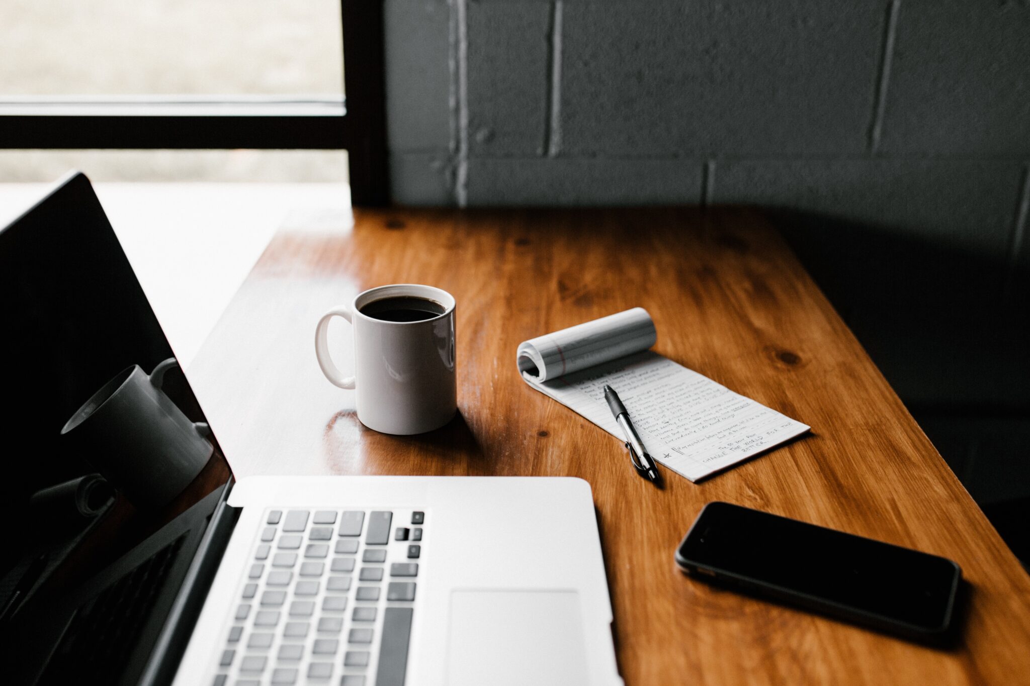Desk with laptop, coffee and pad of paper