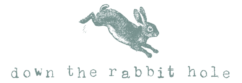 Gray green rabbit hopping over the text "down the rabbit hole" in a typewriter font