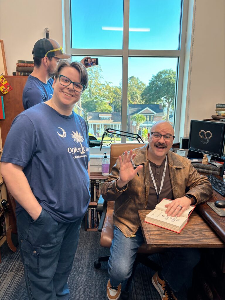 Standing in my Ogier Con shirt next to the distinguished Michael Livingston who is sitting at Robert Jordanās desk and waving and signing my book
