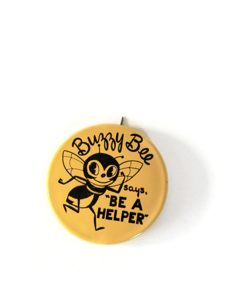 Yellow vintage circular button with a black bee illustrated on it and the words Buzzy Bee says, "Be a helper."