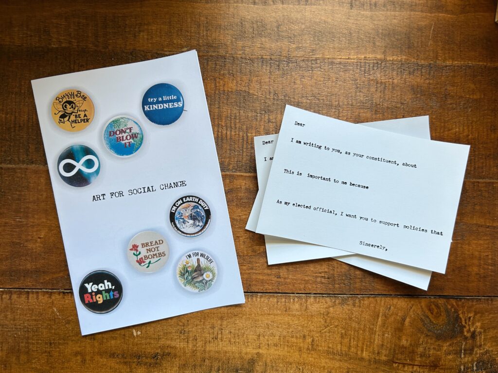 Art for Social Change zine and typewritten postcards. Vintage buttons are on the cover including a yellow Buzzy Bee "be a helper", "try a little kindness", a retro earth pin that says "Don't blow it." an infinity symbol on an outer space badge, "bread not bombs" with a red flower", "yeah rights" in rainbow colors, "I'm on earth duty" and "I'm for wildlife" with a bird and wildflowers.