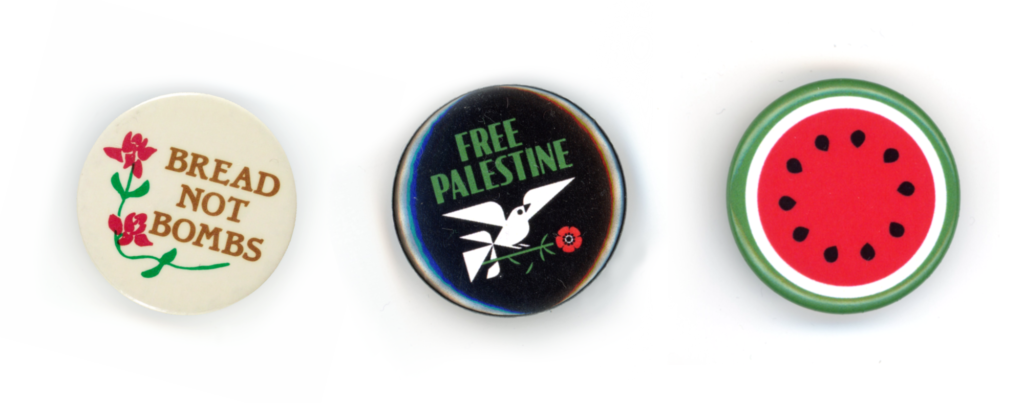 Three round pins. The first is a vintage pin with red flowers that says "Bread not bombs." The second is a black pin with white bird holding a red flower that says "Free Palestine." The third is a circular slice of watermelon.