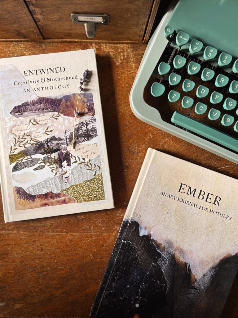 Entwined and Ember books on a table with a teal green typewriter and library style drawers. Entwined has a collage cover with mother and child and hand illustrated vines. Ember has a burned wood texture on the cover.