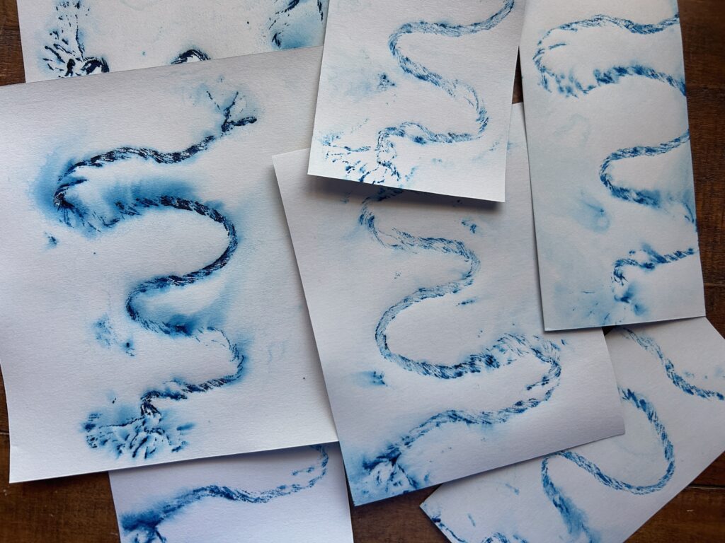 Collograph prints of deep blue meanders of a river as printed from an unraveling cord