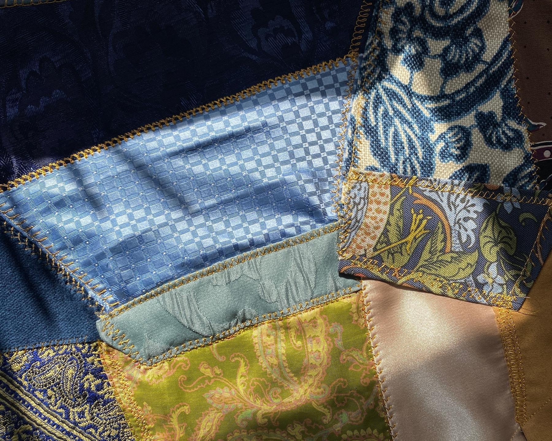 Crazy quilted patchwork with various textures in blue and green